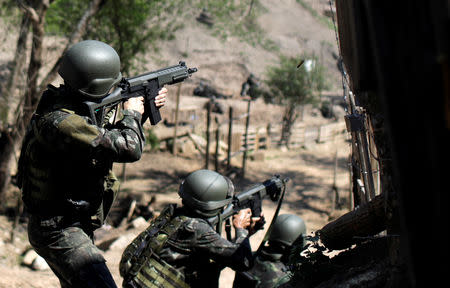 Brazilian Army soldiers fire their weapons during a shootout with drug gangs during an operation in Alemao slums complex in Rio de Janeiro, Brazil August 20, 2018. REUTERS/Ricardo Moraes