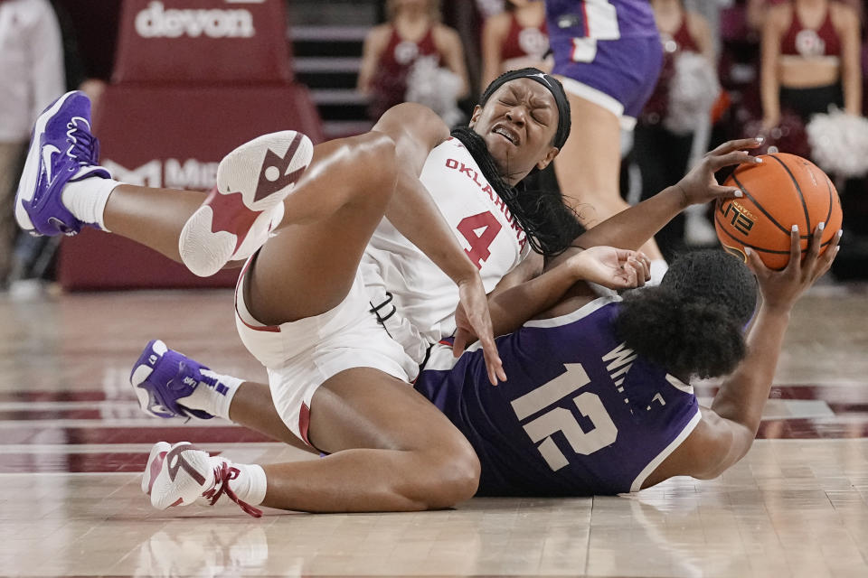 Oklahoma guard Kennady Tucker (4) and TCU forward Bre'Yon White (12) fight for control of the ball in the first half of an NCAA college basketball game Tuesday, Jan. 31, 2023, in Norman, Okla. (AP Photo/Sue Ogrocki)