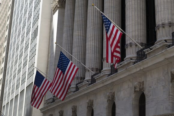 New York Stock Exchange building, with angled view and three flags visible.