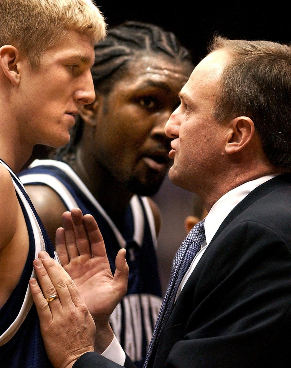 Xavier head coach Thad Matta talks to Justin Doellman, with Anthony Myles in the background, during a timeout in the Musketeers' 87-67 upset of No. 1-ranked St. Joseph's in the Atlantic 10 tournament.
