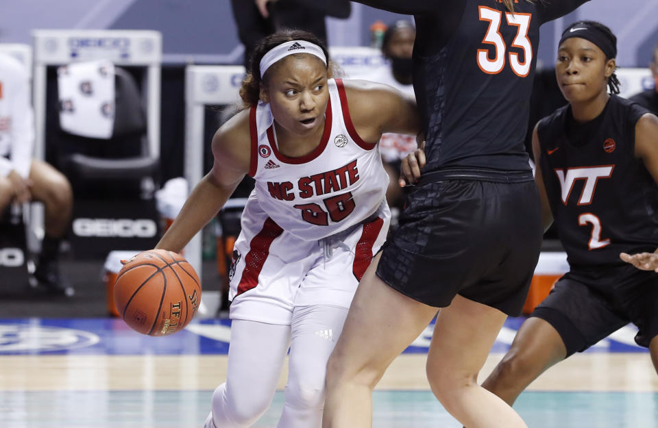 North Carolina State's Kayla Jones (25) drives around Virginia Tech's Elizabeth Kitley (33) during the first half of an NCAA college basketball game in the Atlantic Coast Conference women's tournament in Greensboro, N.C., Friday, March 5, 2021. (Ethan Hyman/The News & Observer via AP)