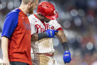 Philadelphia Phillies' Jean Segura, right, examines his arm after being hit by a pitch from Washington Nationals' Joe Ross during the fifth inning of a baseball game, Monday, July 26, 2021, in Philadelphia. (AP Photo/Laurence Kesterson)