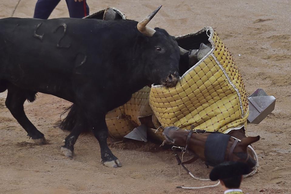 <p>A bull charges against a horse after a ‘Picador’ assistant bullfighter was knocked off the horse during a bullfight at the San Fermin Fiestas in Pamplona, Spain, July 9, 2017. (AP Photo/Alvaro Barrientos) </p>