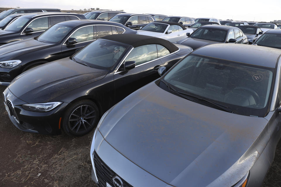 Unused rental cars fill a dusty field near Kahului Airport, Friday, Sept. 1, 2023, in Kahului, Hawaii. So few tourists are coming to the Hawaiian island of Maui after last month's wildfires that restaurants and tour companies are laying off workers and unemployment is surging. State tourism officials initially urged travelers to stay away but now want them to come back so long as they refrain from going to the burn zone and surrounding area. (AP Photo/Marco Garcia)