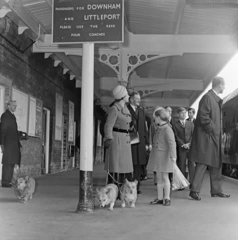 <p>Hobson/Mirrorpix/Getty</p> Queen Elizabeth and her corgis arrive at Sandringham Train Station in Dec. 1970