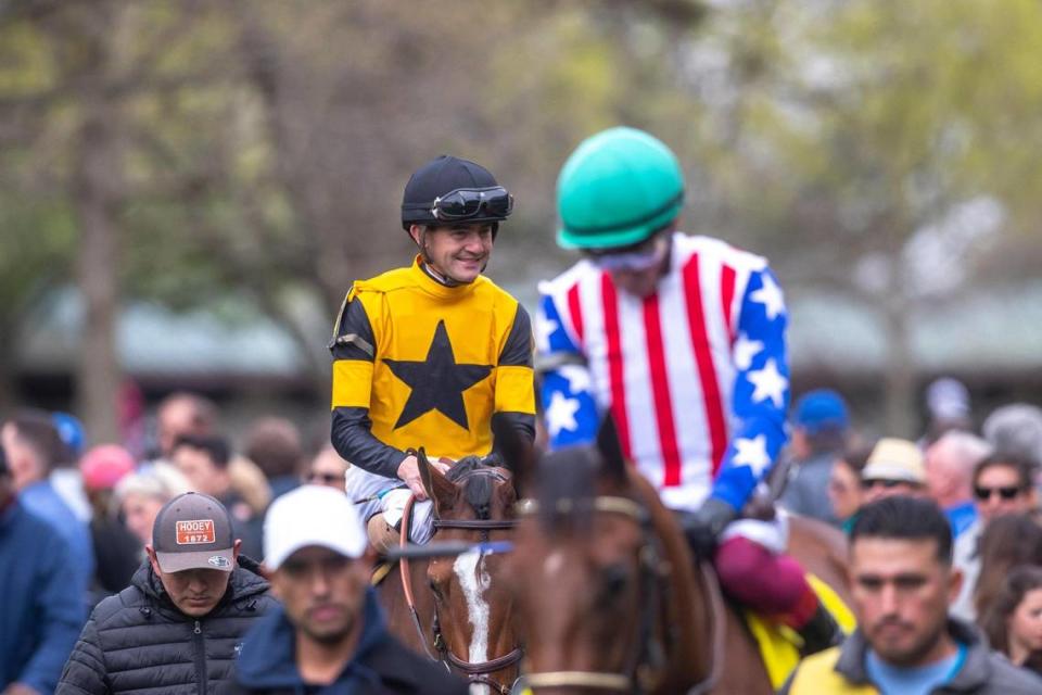 Jockeys ride their horses through the paddock at Keeneland on the first day of the Spring Meet on Friday.