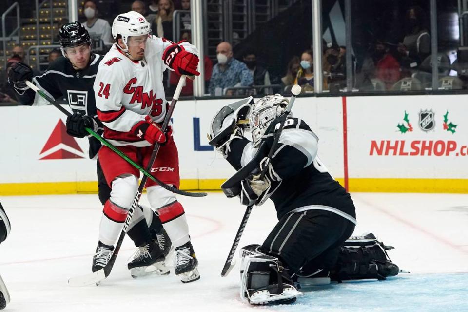 Los Angeles Kings goaltender Cal Petersen, right, stop a shot in front of Carolina Hurricanes center Seth Jarvis (24) during the first period of an NHL hockey game Saturday, Nov. 20, 2021, in Los Angeles. (AP Photo/Marcio Jose Sanchez)