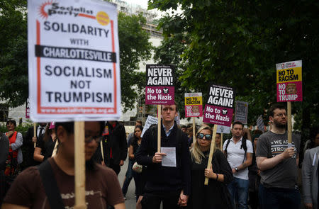 Demonstrators hold placards during an anti-fascist protest outside the U.S Embassy in London, Britain, August 14, 2017. REUTERS/Hannah McKay