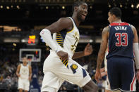 Indiana Pacers guard Caris LeVert (22) reacts after scoring a basket as he runs behind Washington Wizards forward Kyle Kuzma (33) during the second half of an NBA basketball game in Indianapolis, Monday, Dec. 6, 2021. (AP Photo/AJ Mast)