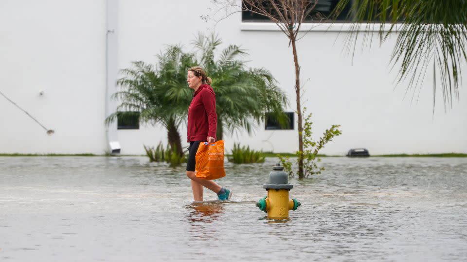 Local resident Valerie Childress walks through flooding in St. Petersburg, Florida. - Jefferee Woo/Tampa Bay Times/Zuma Press