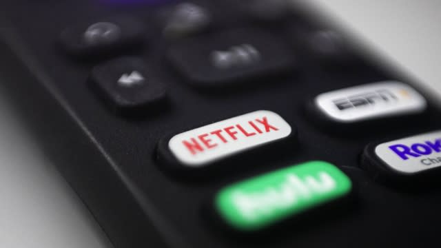 Logos for Netflix, Hulu, ESPN and Roku are shown on a remote control.