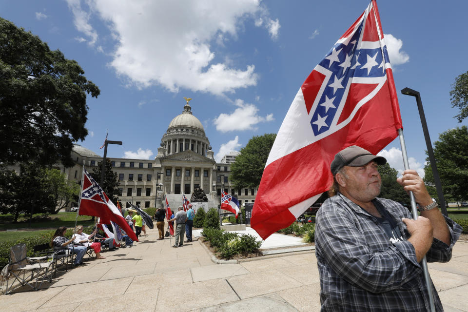 FILE - In this Sunday, June 28, 2020, file photo, David Flynt of Hattiesburg, stands outside the state Capitol with other current Mississippi flag supporters in Jackson, Miss. "I love this flag," Flynt said. Mississippi's Republican-controlled Legislature voted Sunday to remove the Civil War emblem from the state flag. (AP Photo/Rogelio V. Solis, File)
