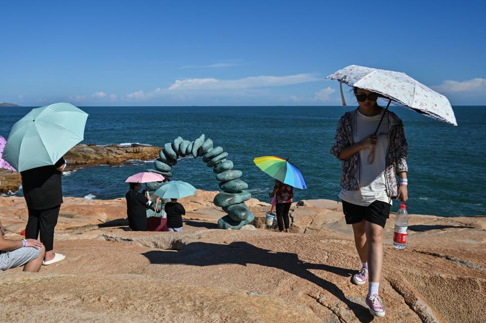 Tourists visit a scenic area on Pingtan island, one of mainland China’s closest point from Taiwan, in Fujian province on 5 August 2022 (AFP via Getty Images)