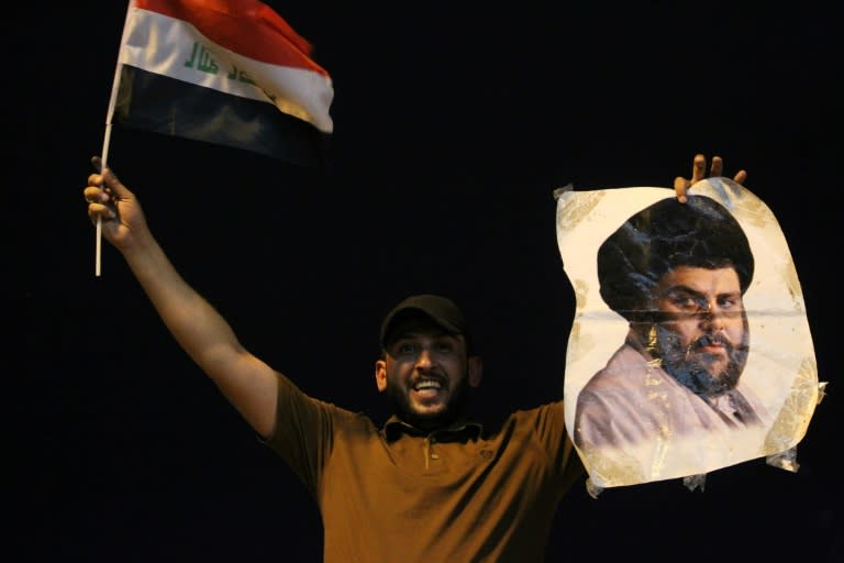 An Iraqi man celebrates with a picture of Shiite cleric Muqtada Sadr during the general election in Baghdad on May 14, 2018