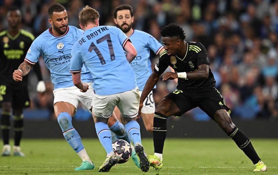 Real Madrid&#39;s Brazilian forward Vinicius Junior (R) vies Manchester City&#39;s English defender Kyle Walker (L), Manchester City&#39;s Belgian midfielder Kevin De Bruyne (2L) and Manchester City&#39;s Portuguese midfielder Bernardo Silva with during the UEFA Champions League second leg semi-final football match between Manchester City and Real Madrid at the Etihad Stadium in Manchester, north west England, on May 17, 2023 - Getty Images/Paul Ellis