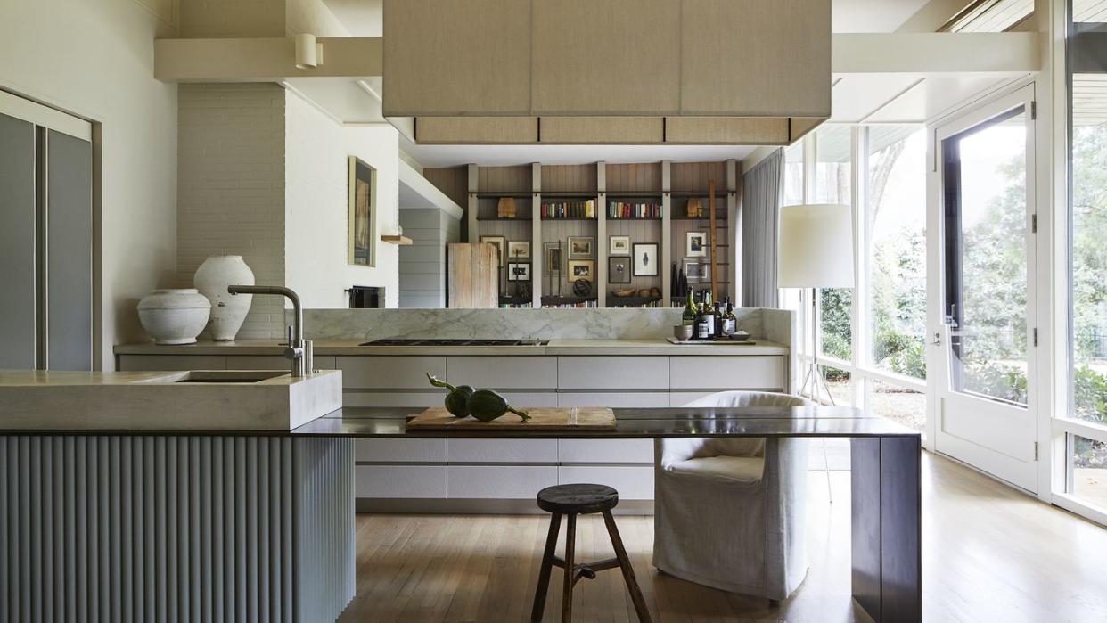 a thin plated steel prep counter extends off the sink to face the den