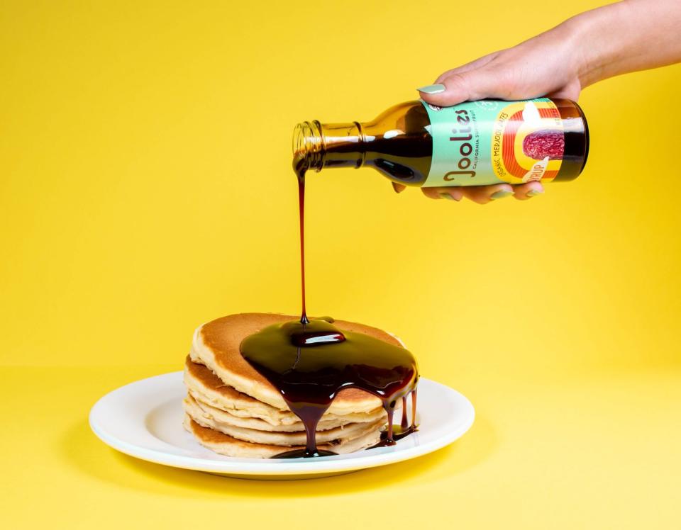 date syrup being poured onto pancakes