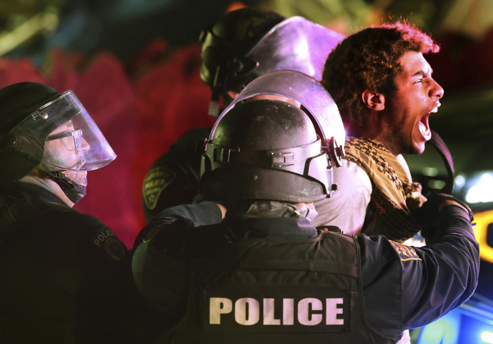 Tucson Police take a protester into custody on Park Avenue as law enforcement personnel from several area agencies clear an encampment of pro-Palestinian protesters from the University of Arizona campus, early Wednesday, May 1, 2024, in Tucson, Ariz. (Kelly Presnell/Arizona Daily Star via AP)