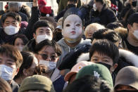 A small business owner wears a mask of the 'Younghee', a doll from Netflix's series "Squid Game", during a rally against the government's social distancing rules near the Government Complex in Seoul, South Korea, Wednesday, Dec. 22, 2021. Hundreds of small business owners rallied on Wednesday, calling for the withdrawal of curfews and other strict COVID-19 restrictions on restaurants, cafes, gyms and other facilities. (AP Photo/Ahn Young-joon)