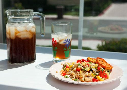 colorful couscous salad with a pitcher of iced tea