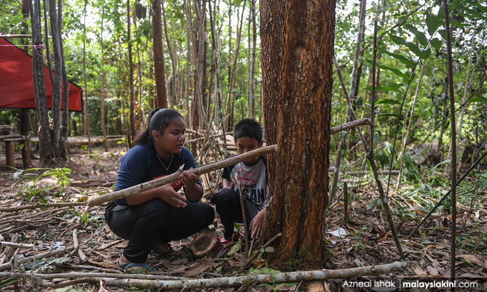 UiTM Segamat student Zarina Ramli looks for wood to reinforce the hut. Improving the hut is a continuous process.