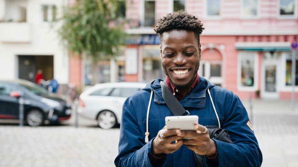 man smiling while using smartphone