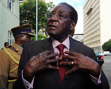 FILE PHOTO: Zimbabwe's President Mugabe speaks to journalists outside Parliament in Harare
