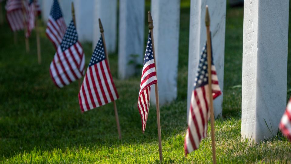 Members of the 3rd United States Infantry Regiment, also known as The Old Guard, place flags in front of each headstone as part of the "Flags In" ceremony at Arlington National Cemetery in Arlington, Va. on Thursday, May 27, 2021. Since 1948, The Old Guard has placed flags at each headstone in honor of Memorial Day.