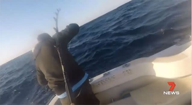 Damian Jackson helps to reel in the two-metre marlin. Picture: Supplied