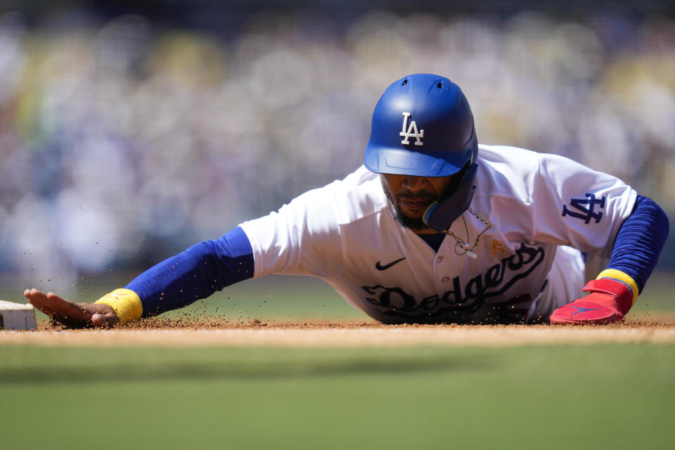 Los Angeles Dodgers' Mookie Betts dives safely back to first base during the third inning of a baseball game against the Atlanta Braves in Los Angeles, Sunday, Sept. 3, 2023. (AP Photo/Ashley Landis)