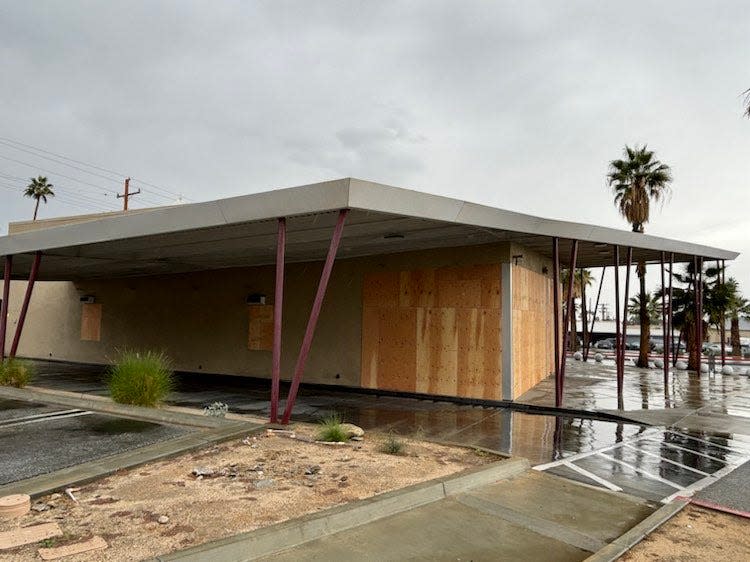 Wood boards cover the windows of what was formerly a KFC restaurant in Palm Springs.