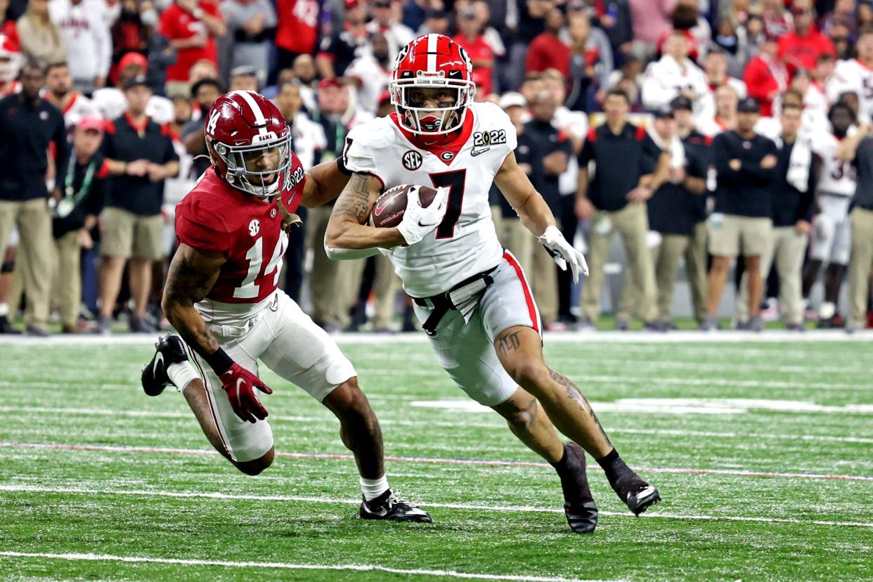 Jan 10, 2022; Indianapolis, IN, USA; Georgi wide receiaver Jermaine Burton (7) runs the ball against Alabama Crimson Tide defensive back Brian Branch (14) in the 2022 CFP college football national championship game at Lucas Oil Stadium. Trevor Ruszkowski-USA TODAY Sports