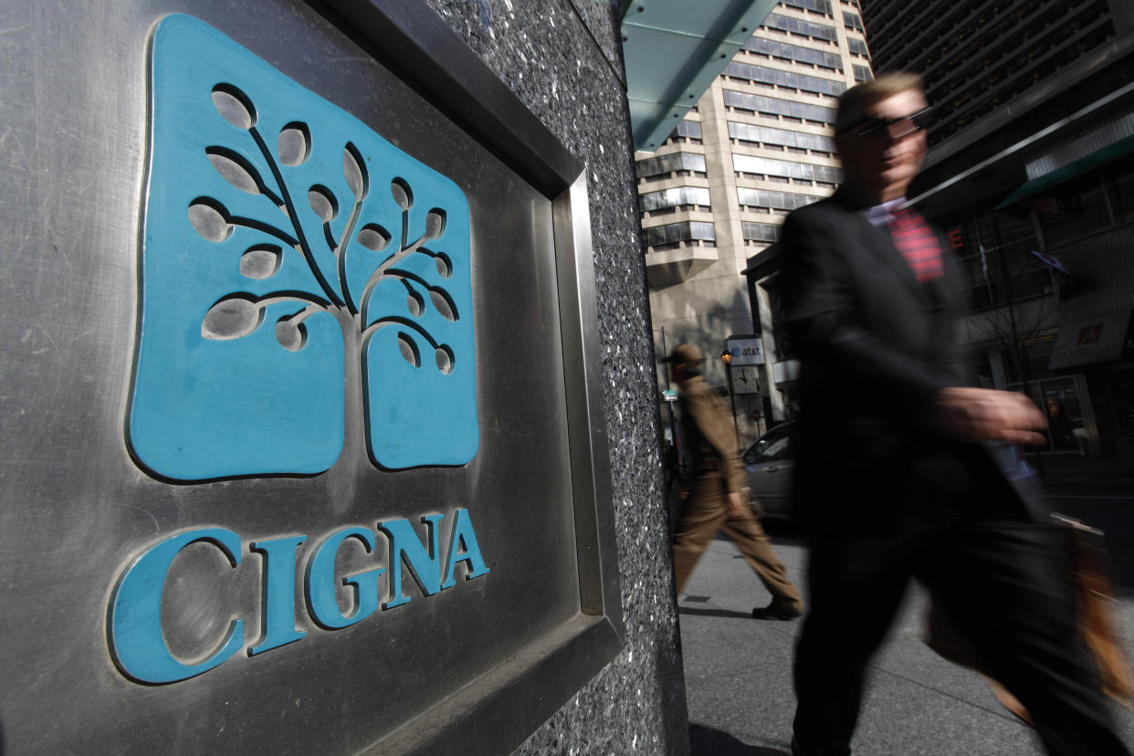 FILE - In this Nov. 17, 2009 file photo, a pedestrian walks past the headquarters of the health insurer Cigna Corp. in in Philadelphia. Managed care company Cigna said Friday, Oct. 29, 2010, its third-quarter profit fell 6.7 percent on higher medical costs and losses from the company's reinsurance segment.(AP Photo/Matt Rourke, file)