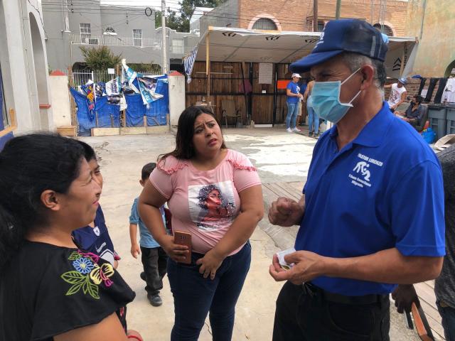 Pastor Lorenzo Ortiz, right, meets with migrants at one of the shelters he runs in Nuevo Laredo, Mexico. Ortiz worries that the return of the Trump administration&#39;s Remain in Mexico policy will put more migrants at risk.