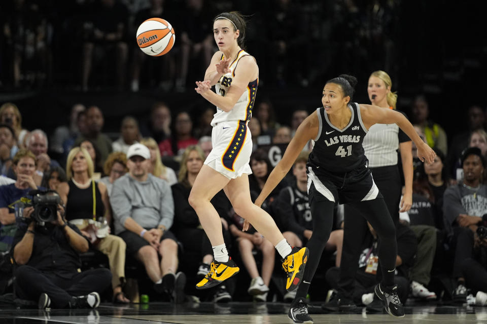 Indiana Fever guard Caitlin Clark (22) passes against Las Vegas Aces center Kiah Stokes (41) during the first half of a WNBA basketball game Saturday, May 25, 2024, in Las Vegas. (AP Photo/John Locher)