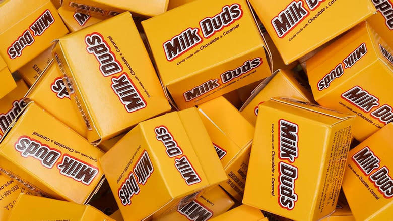 pile of mini Milk Duds boxes