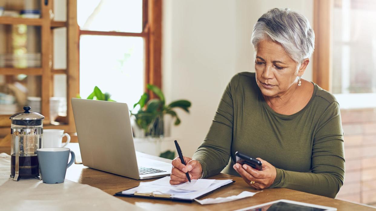 Shot of a mature woman going through paperwork at home.