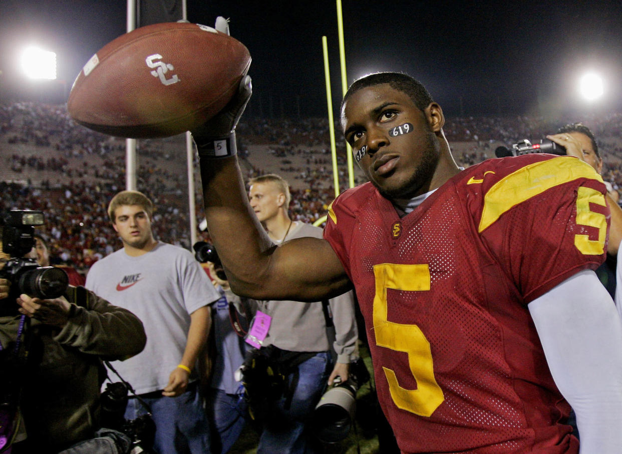 FILE - Southern California tail back Reggie Bush walks off the field holding the game ball after the Trojans defeated Fresno State, 50-42, at the Los Angeles Coliseum on Nov. 19, 2005. Reggie Bush, whose Heisman Trophy victory for Southern California in 2005 was vacated because of NCAA violations, was among 18 players in the latest College Football Hall of Fame class announced Monday, Jan. 9, 2023. (AP Photo/Kevork Djansezian, File)