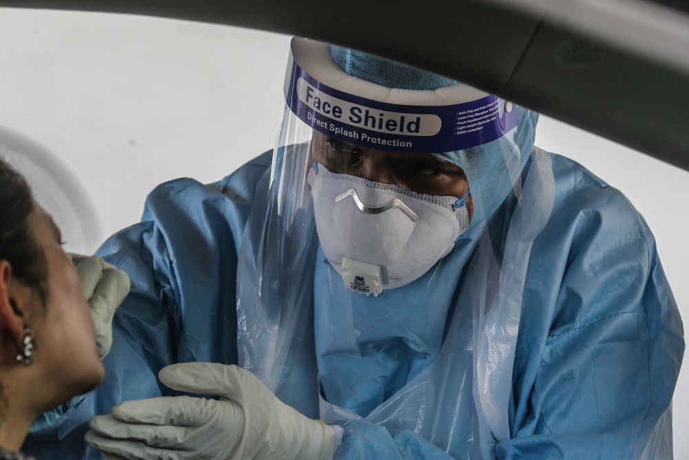 A health worker swabs a driver’s mouth at a drive-through testing site for Covid-19 at KPJ Ampang Puteri, April 6, 2020. — Picture by Firdaus Latif