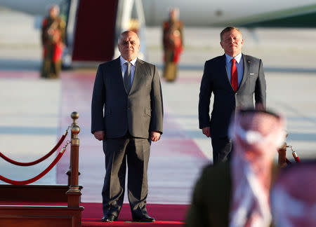 Jordan's King Abdullah II stands next to Iraqi Prime Minister Haider al-Abadi during a reception ceremony at the Queen Alia International Airport in Amman, Jordan March 28, 2017. REUTERS/Muhammad Hamed