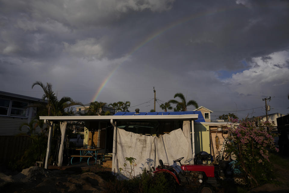 A rainbow arcs over the back porch of the Hurricane Ian-damaged home of the Velazquez family in Fort Myers Beach, Fla., Wednesday, May 24, 2023. Since buying the house with her husband in 2000, Jacquelyn Velazquez said she had lushly landscaped the backyard with palm trees, flowering plants, and a green wall for privacy. After the storm, only one bougainvillea bush survives. (AP Photo/Rebecca Blackwell)