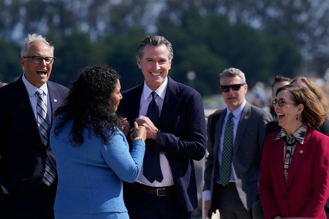 California Gov. Gavin Newsom, middle, smiles while greeting San Francisco Mayor London Breed, second from left, in front of Washington Gov. Jay Inslee, left, and Oregon Gov. Kate Brown, right, while walking along a path at the Presidio Tunnel Tops in San Francisco, Thursday, Oct. 6, 2022.