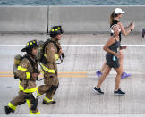 In this photo provided by the Florida Keys News Bureau, firefighters run in full bunker gear during the annual Seven Mile Bridge Run Saturday, April 1, 2023, near Marathon, Fla. The annual footrace attracted 1,500 runners that traversed the longest of 42 bridges over water that help comprise the Florida Keys Overseas Highway. Joanna Stephens, 28, of Atlanta won the overall women's title and Vaclav Bursa, 15, of Big Pine Key, Fla., won the overall men's division. (Andy Newman/Florida Keys News Bureau via AP)