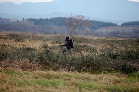 A migrant runs through a field after crossing the border from Greece into Macedonia, near Gevgelija, Macedonia, November 26, 2015. REUTERS/Stoyan Nenov