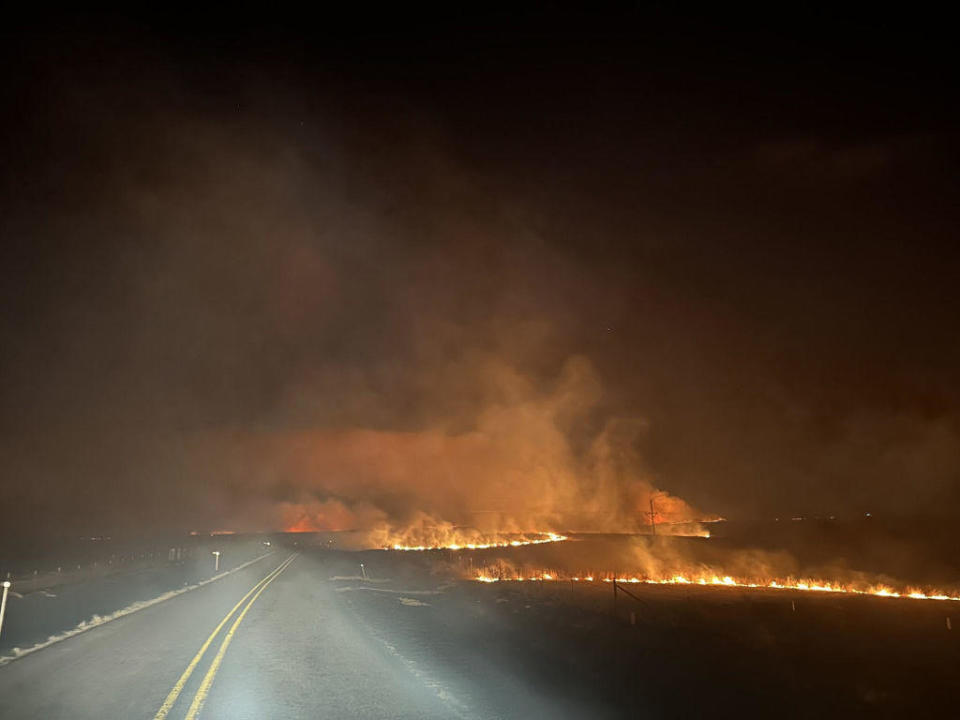 In this handout photo provided by the Texas A&M Forest Service, flames cross a road in the Smokehouse Creek fire on the evening of Feb. 27, 2024, in the Texas Panhandle. The blaze has grown to more than 850,000 acres since igniting Monday, making it the second-largest wildfire in Texas state history. / Credit: Texas A&M Forest Service/Getty Images