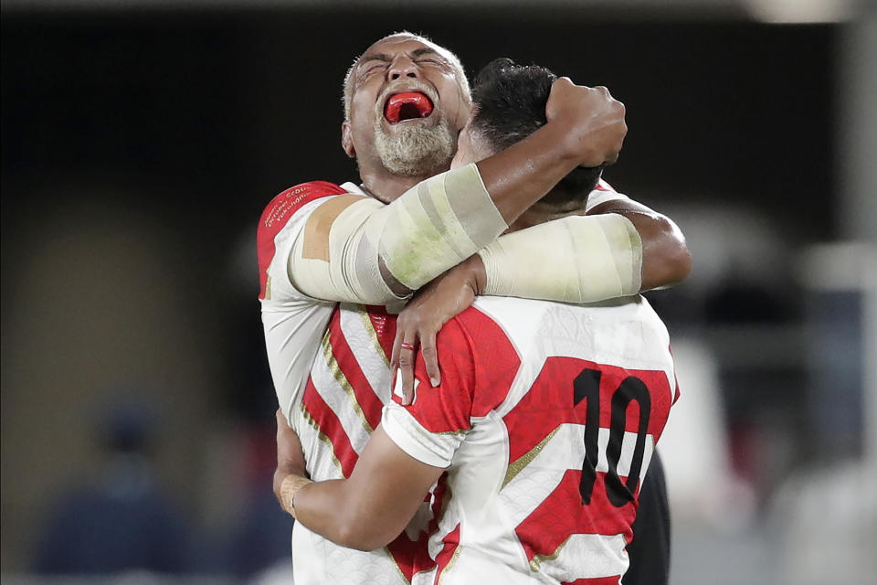 Japan's Isileli Nakajima, left, celebrates with Yu Tamura after the Rugby World Cup Pool A game at International Stadium against Scotland in Yokohama, Japan, Sunday, Oct. 13, 2019. Japan won 28-21. (AP Photo/Jae Hong)