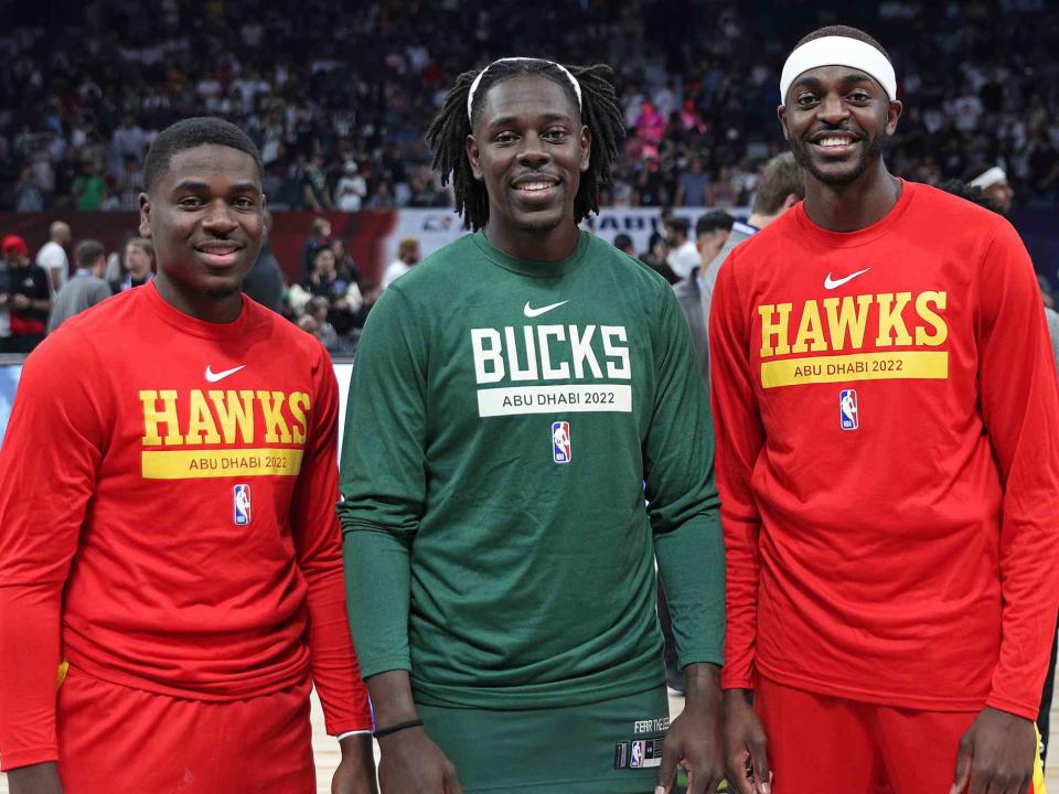 Chris Marion/NBAE/Getty Aaron Holiday #4 and Justin Holiday #8 of the Atlanta Hawks pose for a photo with Jrue Holiday #21 of the Milwaukee Bucks before the 2022 NBA Abu Dhabi Game.