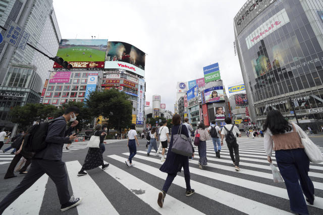 People wearing protective masks to help curb the spread of the coronavirus walk along a pedestrian crossing Thursday, June 24, 2021, in Tokyo. (AP Photo/Eugene Hoshiko)
