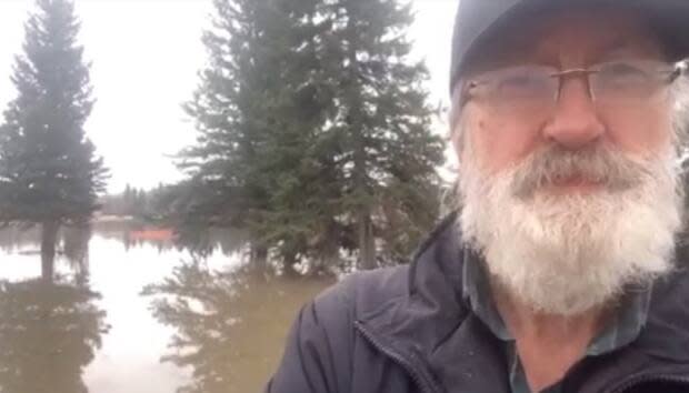 Fort Simpson Mayor Sean Whelly speaks to the CBC Sunday afternoon while standing on the community's causeway in front of its flooded golf course. 