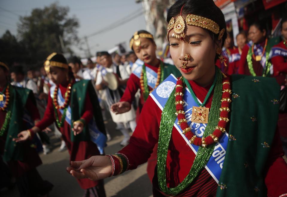 In this Friday, Dec. 30, 2016 photo, Nepalese Gurung community women wear traditional attire dance during a parade to mark their New Year known as "Tamu Loshar" in Kathmandu, Nepal. The indigenous Gurungs, also known as Tamu, are celebrating the advent of the year of the bird. (AP Photo/Niranjan Shrestha, File)